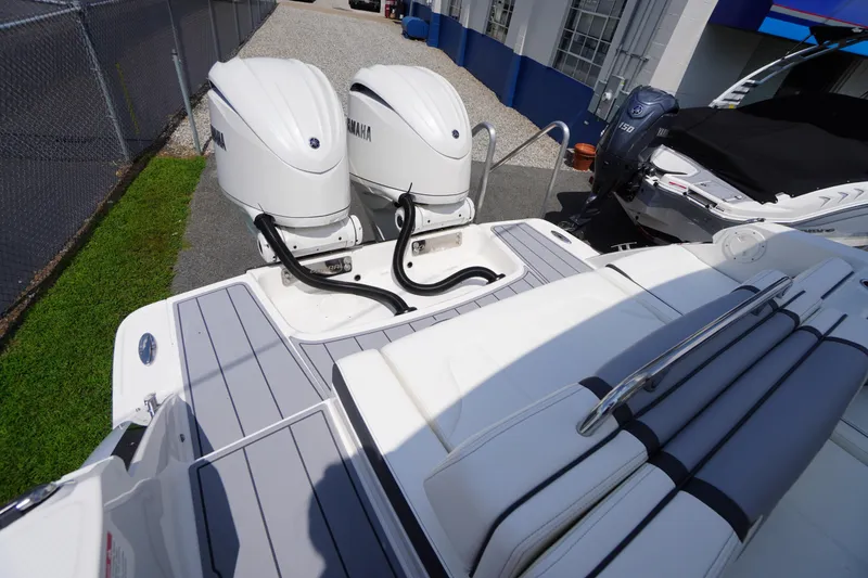 Slide: The Image of 2025 Chaparral 280 OSX boat with dual Yamaha outboard engines, docked outdoors. - 53