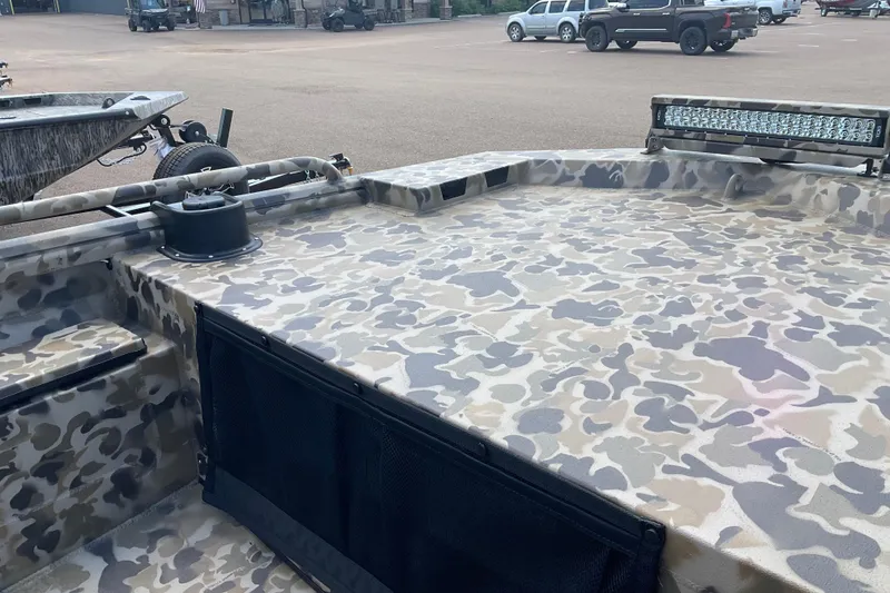 Slide: The Image of 2026 Excel 1754 F4 Shallow Water boat with camouflage design on a trailer. - 2