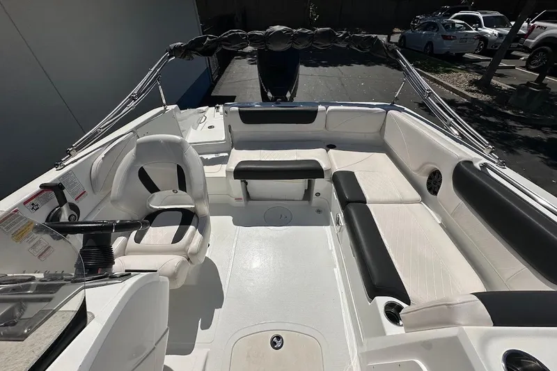 Slide: The Image of 2019 Tahoe 2150 boat interior with white and black seating, steering wheel, and cup holders. - 12