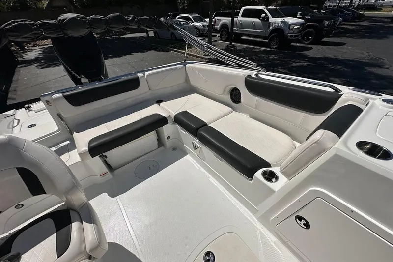 Slide: The Image of 2019 Tahoe 2150 boat interior with white and black seating, cup holders, and storage compartments. - 13