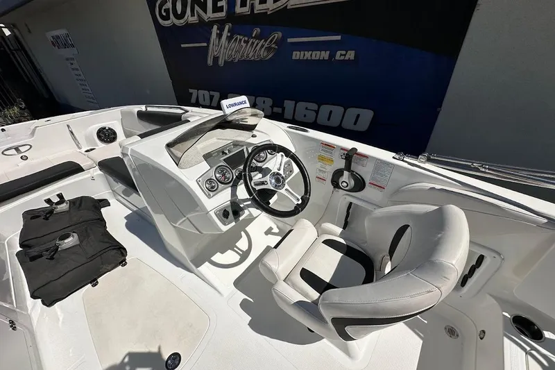 Slide: The Image of 2019 Tahoe 2150 boat interior with steering wheel, gauges, and seating. - 18