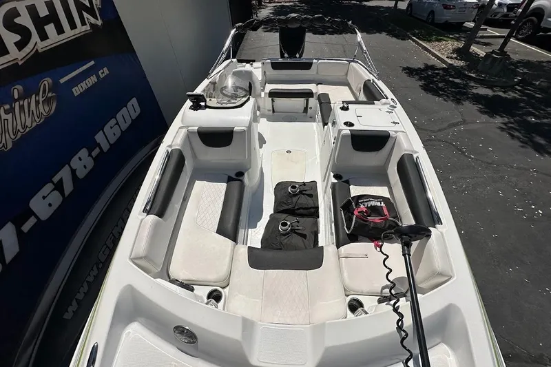 Slide: The Image of 2019 Tahoe 2150 boat interior with seating and equipment, parked outdoors. - 22