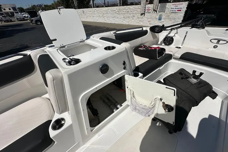 Slide: The Image of 2019 Tahoe 2150 boat interior with open storage compartments and seating. - 25