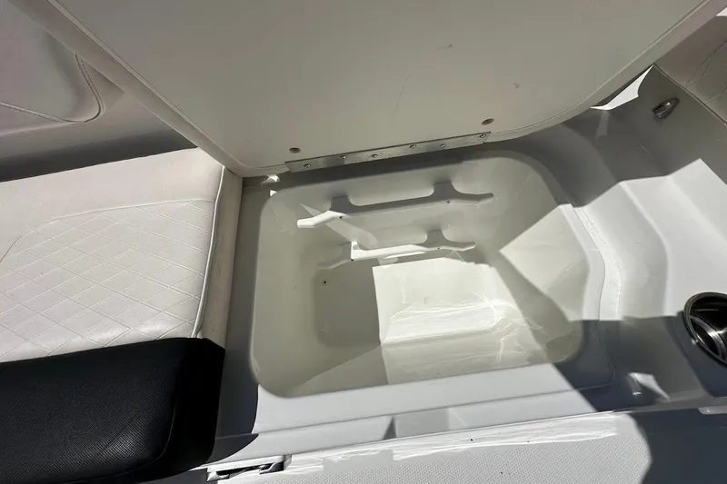 Slide: The Image of Open storage compartment in 2019 Tahoe 2150 boat, featuring white interior and seating. - 32