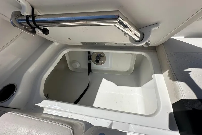 Slide: The Image of 2019 Tahoe 2150 boat storage compartment with stainless steel handle and white interior. - 33