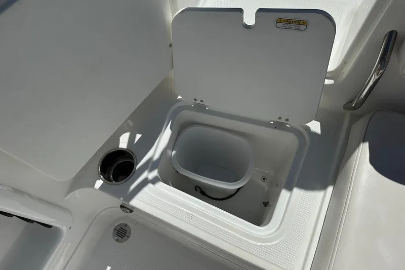 Slide: The Image of 2019 Tahoe 2150 boat storage compartment with open lid and cup holder. - 35