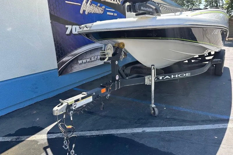 Slide: The Image of 2019 Tahoe 2150 boat on trailer, parked outdoors, with visible hitch and signage in background. - 4