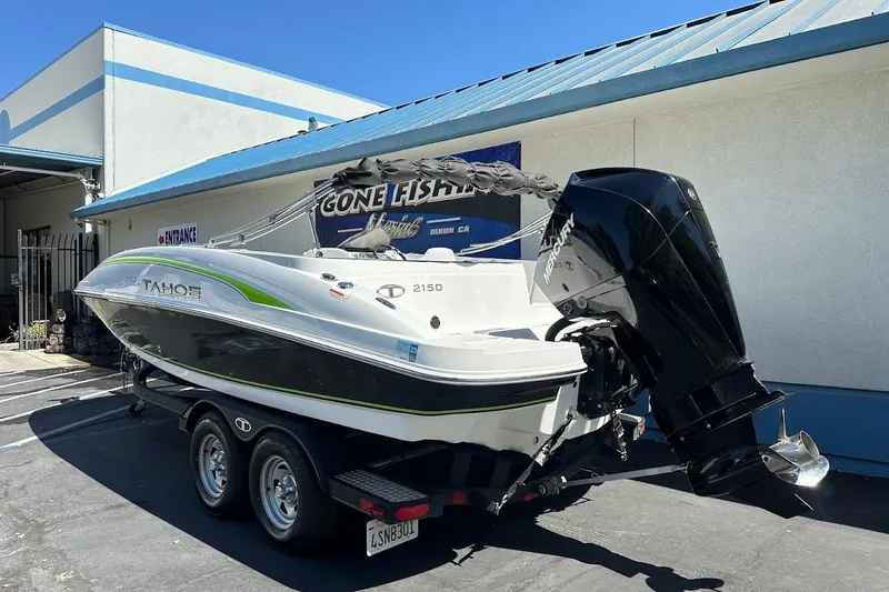 Slide: The Image of 2019 Tahoe 2150 boat with Mercury engine on trailer, parked outside a building. - 7