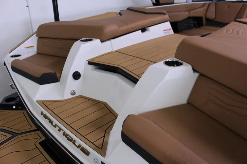 Slide: The Image of 2025 Nautique Super Air G23 boat interior with tan seating and cup holders. - 16