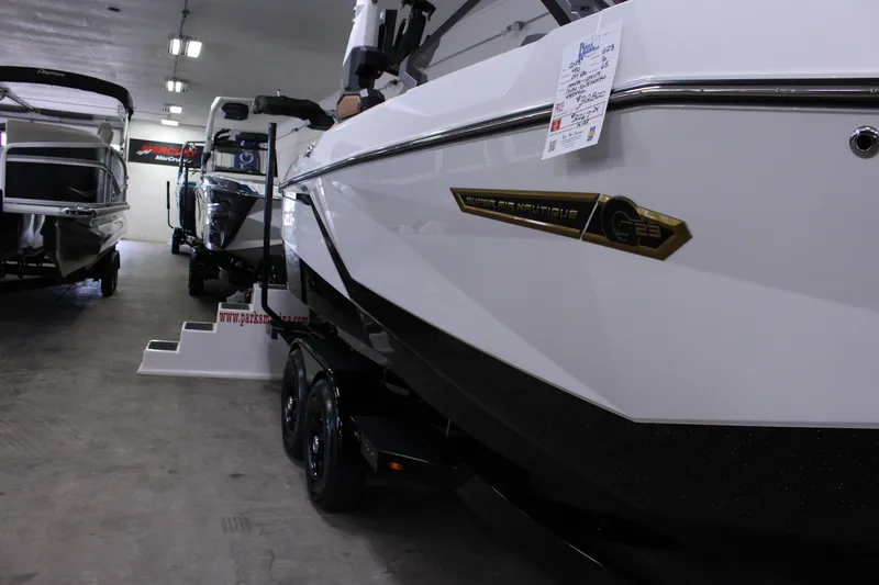 Slide: The Image of 2025 Nautique Super Air G23 boat displayed in showroom, side view. - 3