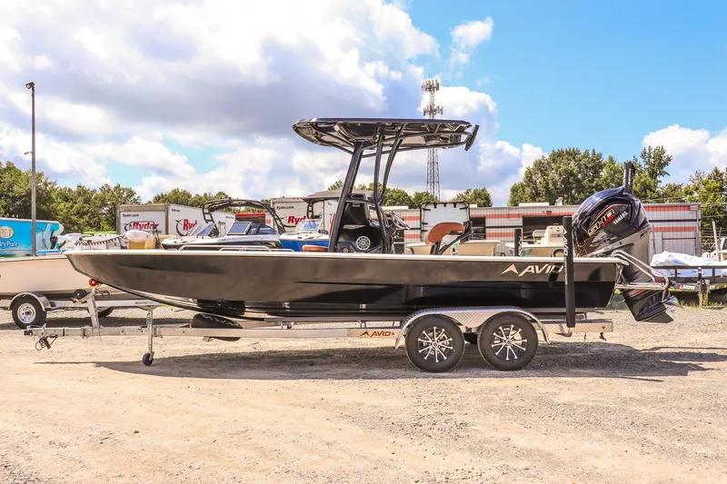 Slide: The Image of 2026 Avid 23 Fusion boat on trailer, parked outdoors under a blue sky. - 2
