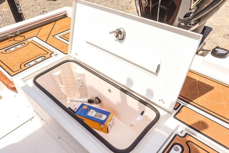 Slide: The Image of Open storage compartment on 2026 Avid 23 Fusion boat with items inside. - 27