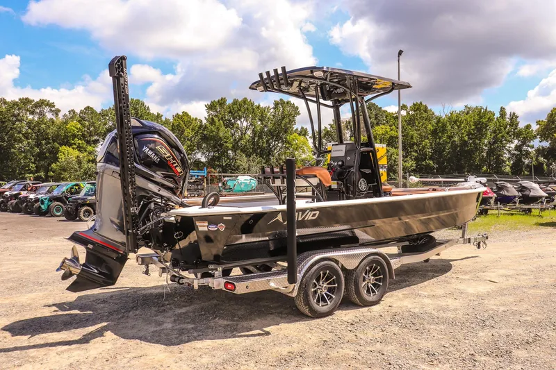 Slide: The Image of 2026 Avid 23 Fusion boat on trailer, parked outdoors under a cloudy sky. - 5