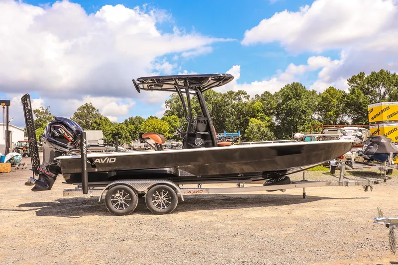 Slide: The Image of 2026 Avid 23 Fusion boat on trailer, outdoors, under blue sky with clouds. - 6