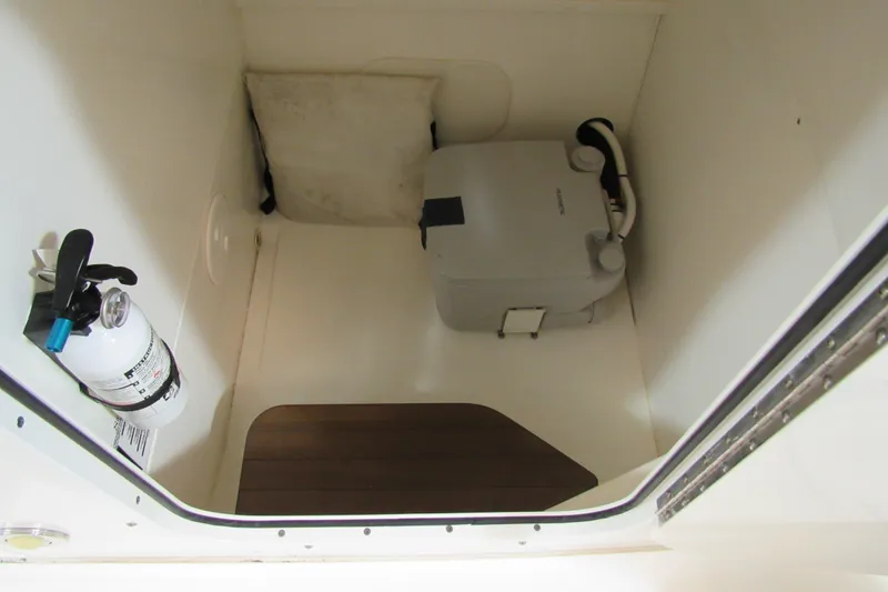 Slide: The Image of 2019 Boston Whaler 270 Dauntless interior storage with fire extinguisher and portable toilet. - 27