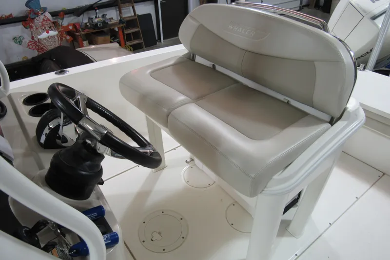 Slide: The Image of 2019 Boston Whaler 270 Dauntless helm with cushioned seating and steering wheel. - 28