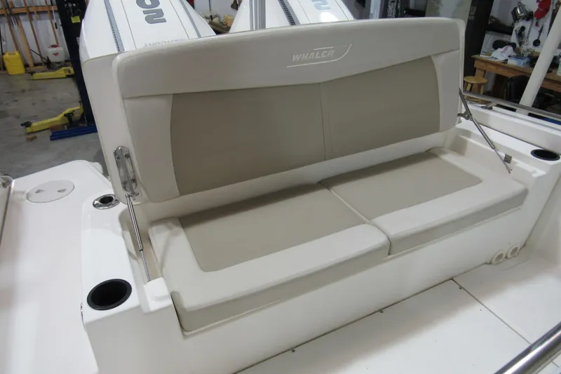 Slide: The Image of 2019 Boston Whaler 270 Dauntless boat seating with beige cushions and cup holders. - 33