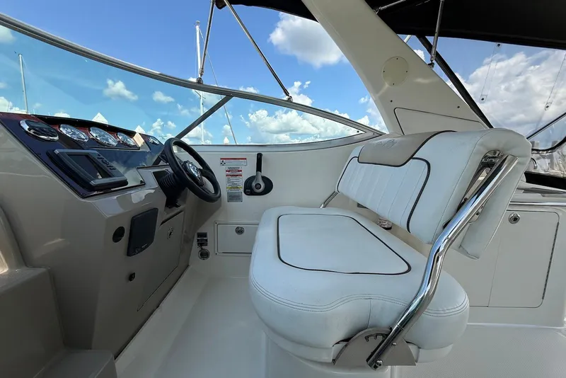 Slide: The Image of 2009 Sea Ray 270 Sundancer helm with white seating and modern dashboard controls. - 11