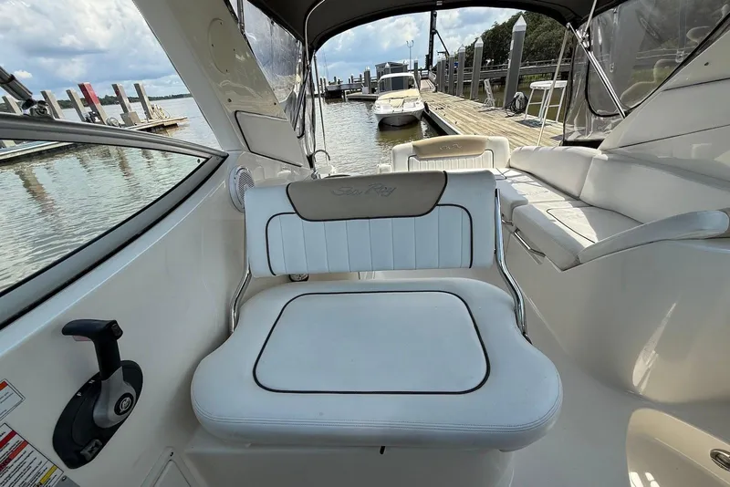 Slide: The Image of 2009 Sea Ray 270 Sundancer interior with white seating, docked at marina. - 12