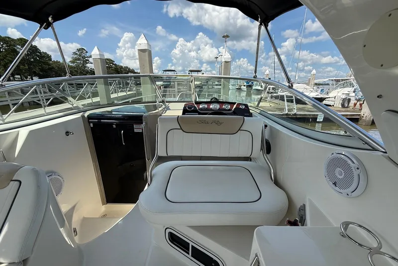 Slide: The Image of 2009 Sea Ray 270 Sundancer boat interior with seating, docked at marina under blue sky. - 13