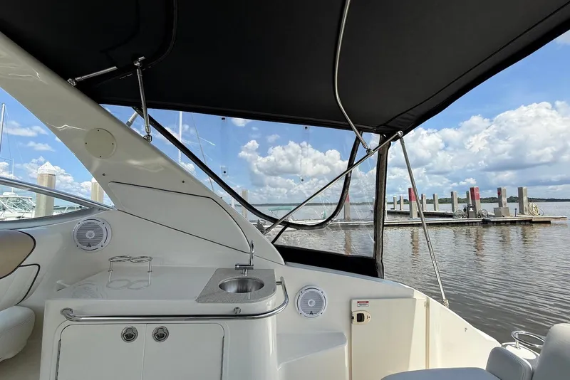 Slide: The Image of 2009 Sea Ray 270 Sundancer interior with sink, speakers, and marina view. - 17