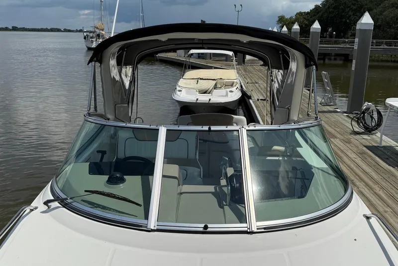 Slide: The Image of 2009 Sea Ray 270 Sundancer docked at marina, featuring sleek design and spacious cockpit. - 18