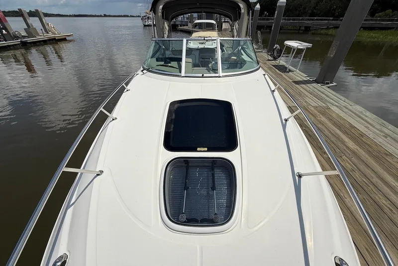 Slide: The Image of 2009 Sea Ray 270 Sundancer docked, showcasing sleek deck design and spacious layout. - 19