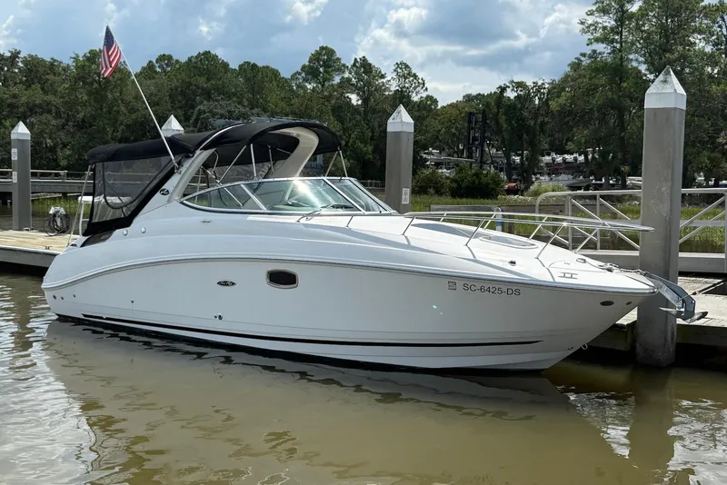 Slide: The Image of 2009 Sea Ray 270 Sundancer docked, featuring sleek design and American flag. - 2