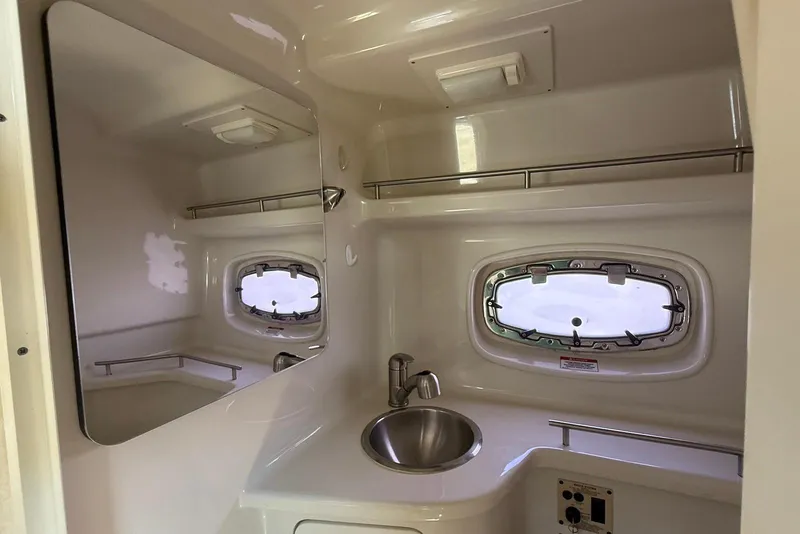 Slide: The Image of 2009 Sea Ray 270 Sundancer bathroom with sink, mirror, and porthole window. - 20