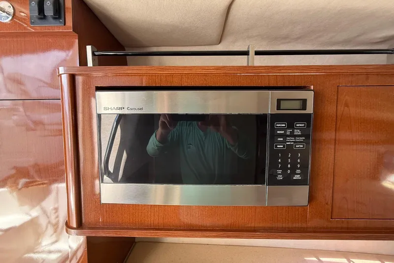 Slide: The Image of Microwave in 2009 Sea Ray 270 Sundancer boat interior, wood paneling. - 23
