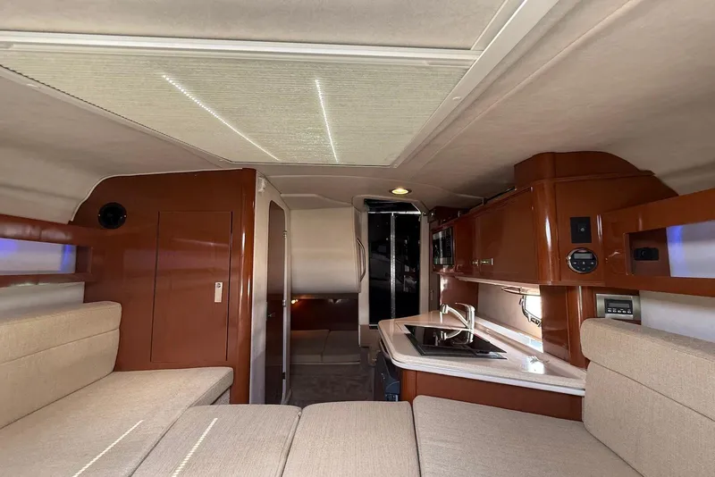 Slide: The Image of Interior of 2009 Sea Ray 270 Sundancer boat with kitchenette and seating area. - 26