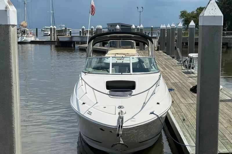 Slide: The Image of 2009 Sea Ray 270 Sundancer docked at marina with American flag in background. - 6