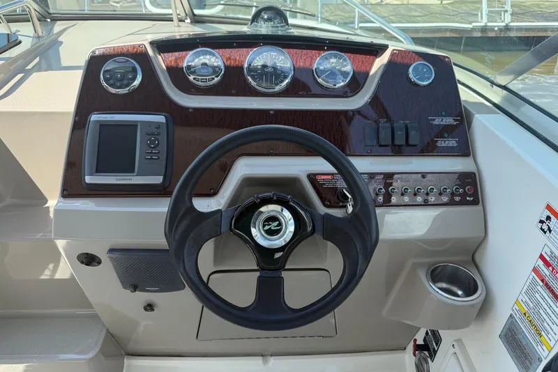 Slide: The Image of Dashboard of a 2009 Sea Ray 270 Sundancer boat with steering wheel and gauges. - 7