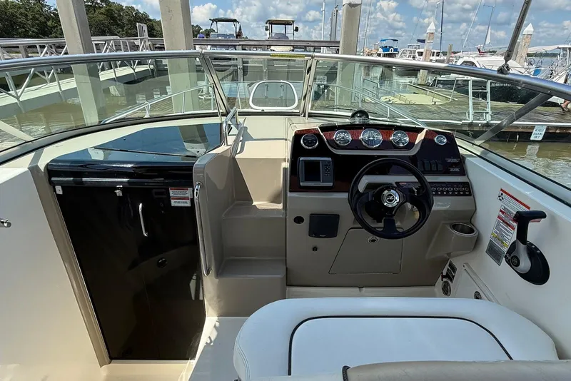 Slide: The Image of 2009 Sea Ray 270 Sundancer boat cockpit with steering wheel and control panel at marina. - 8