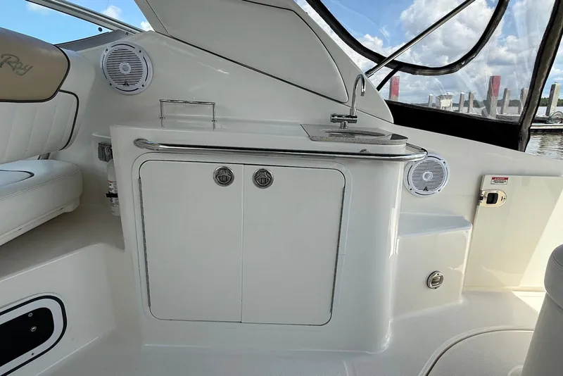 Slide: The Image of 2009 Sea Ray 270 Sundancer interior with sink and storage, featuring sleek design and marine speakers. - 9