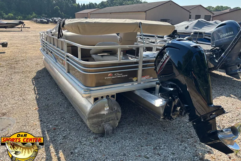 Slide: The Image of 2023 Sun Tracker SportFish 20 DLX pontoon boat with Mercury outboard motor in a dealership lot. - 2