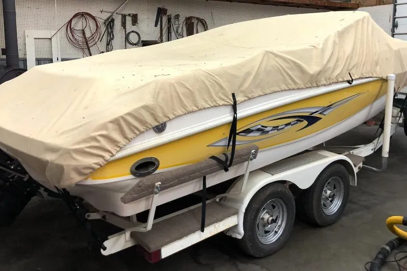 Slide: The Image of 2002 Rinker 212 Captiva BR boat on trailer, covered, in a garage setting. - 18
