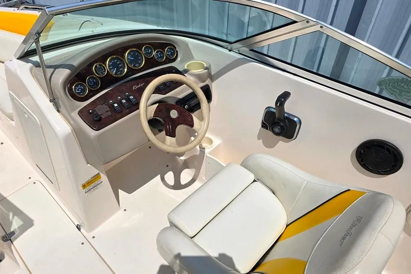 Slide: The Image of 2002 Rinker 212 Captiva BR boat interior with steering wheel and dashboard controls. - 3