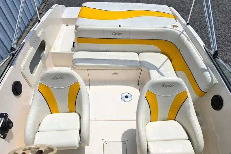 Slide: The Image of 2002 Rinker 212 Captiva BR boat interior with yellow and white seating. - 5
