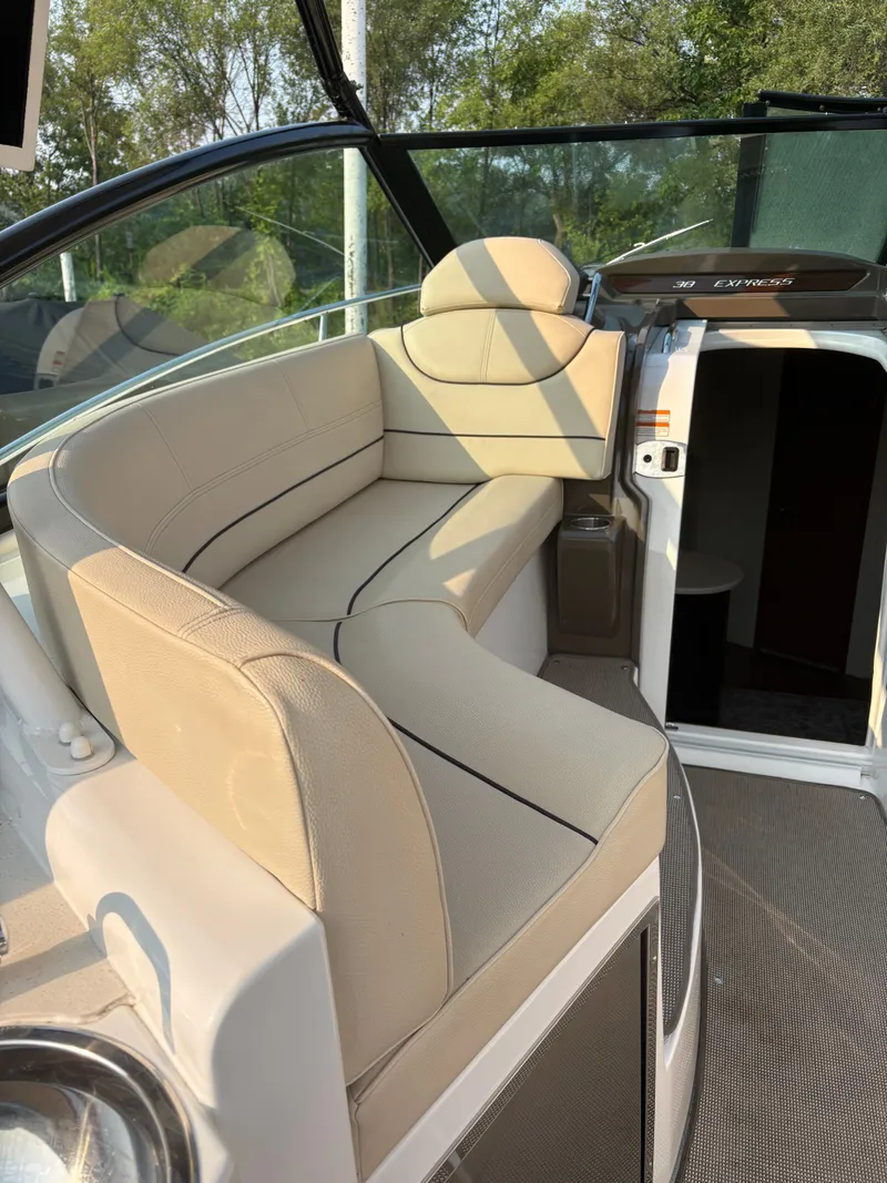 Slide: The Image of 2017 Cruisers Yachts 380 Express interior with beige seating and open cabin door. - 10