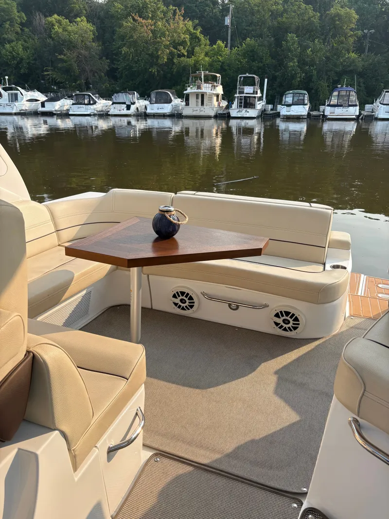 Slide: The Image of 2017 Cruisers Yachts 380 Express interior with seating and table, docked near other boats. - 14