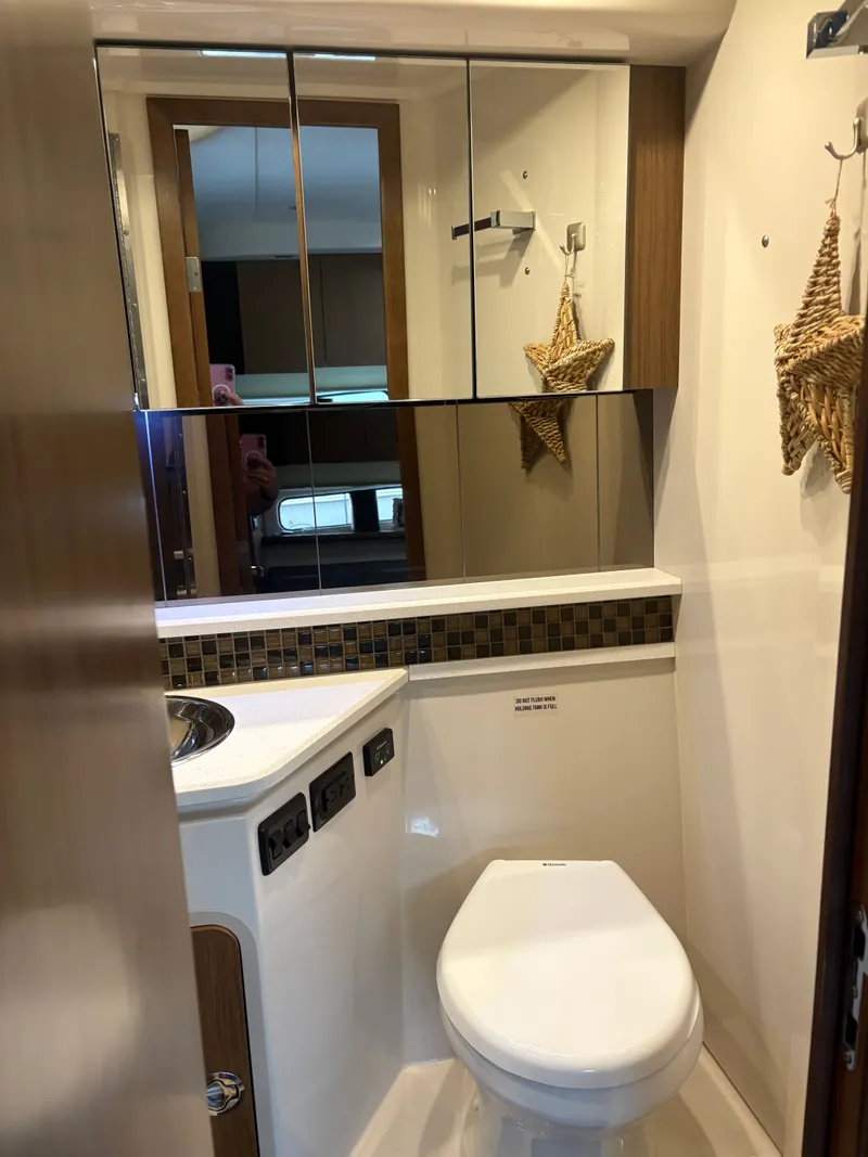 Slide: The Image of 2017 Cruisers Yachts 380 Express bathroom with modern fixtures and mirrored cabinets. - 19