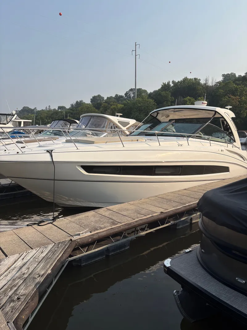 Slide: The Image of 2017 Cruisers Yachts 380 Express docked at marina, side view. - 2