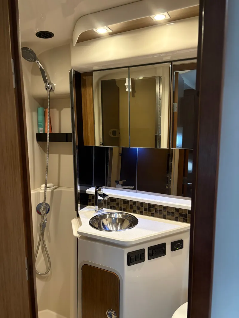 Slide: The Image of 2017 Cruisers Yachts 380 Express bathroom with modern fixtures and mirrored cabinets. - 20