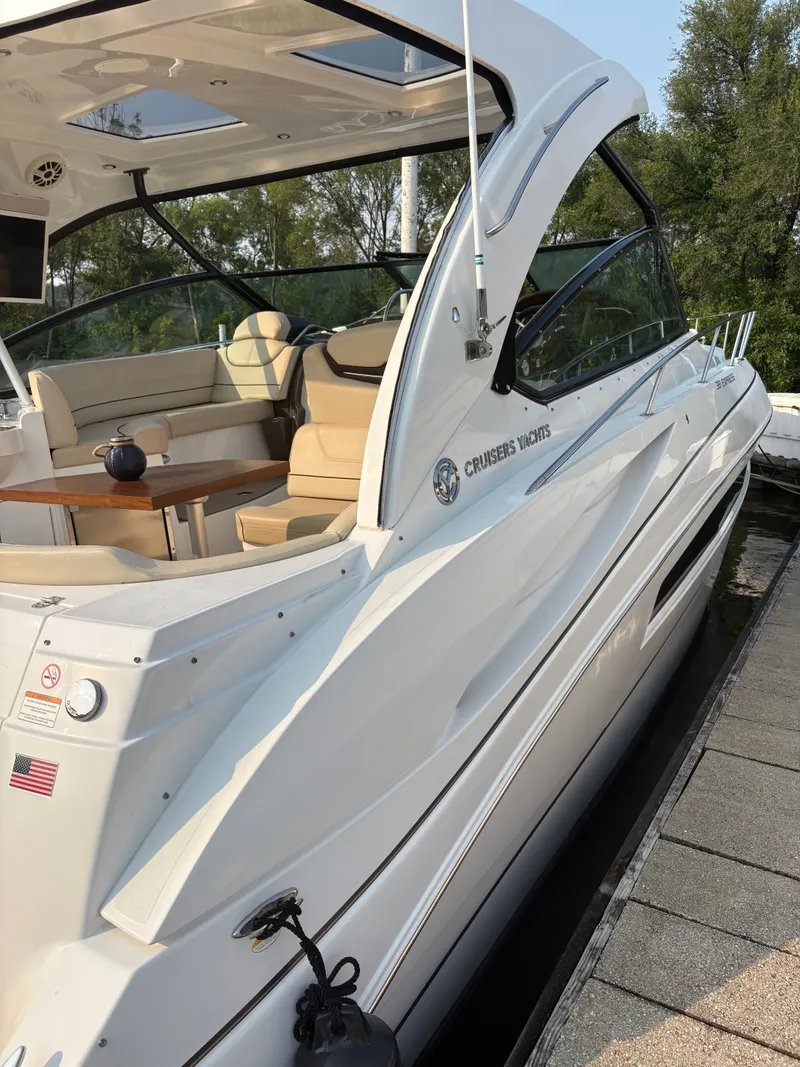 Slide: The Image of 2017 Cruisers Yachts 380 Express, sleek white design, docked with luxurious seating area. - 3