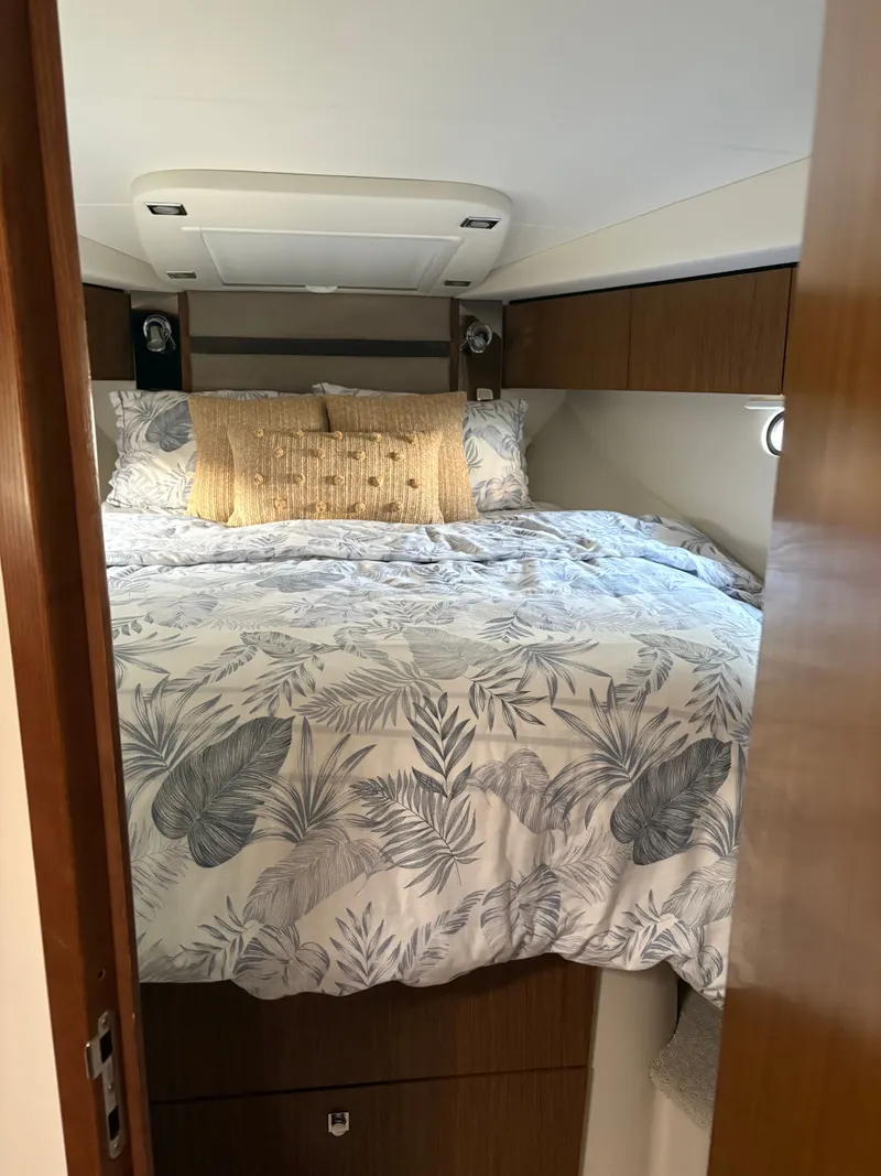 Slide: The Image of Cozy bedroom in 2017 Cruisers Yachts 380 Express with floral bedding and wooden cabinetry. - 5