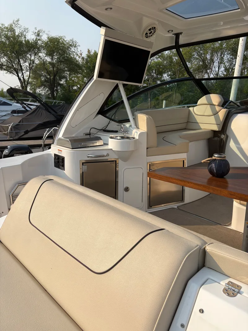 Slide: The Image of 2017 Cruisers Yachts 380 Express interior with seating, table, and entertainment system. - 6