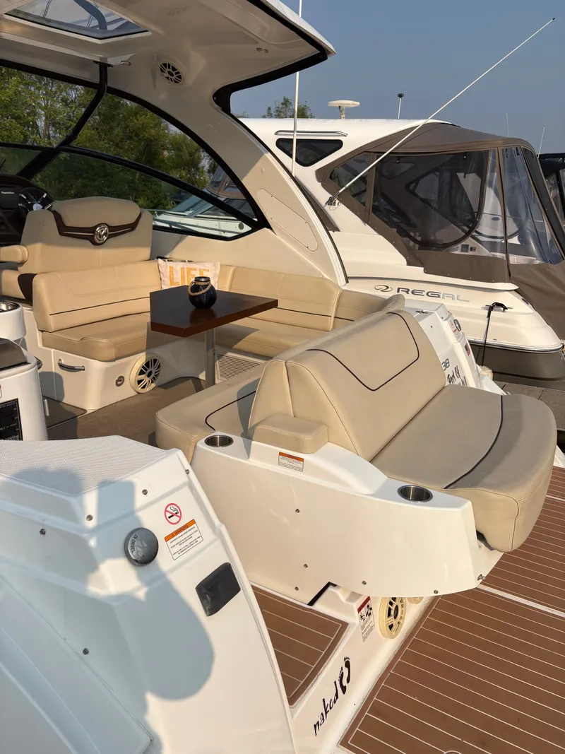 Slide: The Image of 2017 Cruisers Yachts 380 Express interior with beige seating and wooden table. - 8