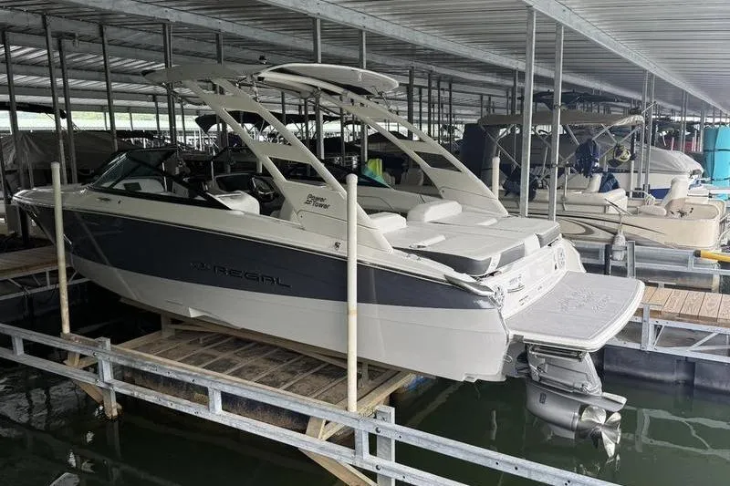 Slide: The Image of 2023 Regal LS2 boat docked in a covered marina, showcasing sleek design and modern features. - 15
