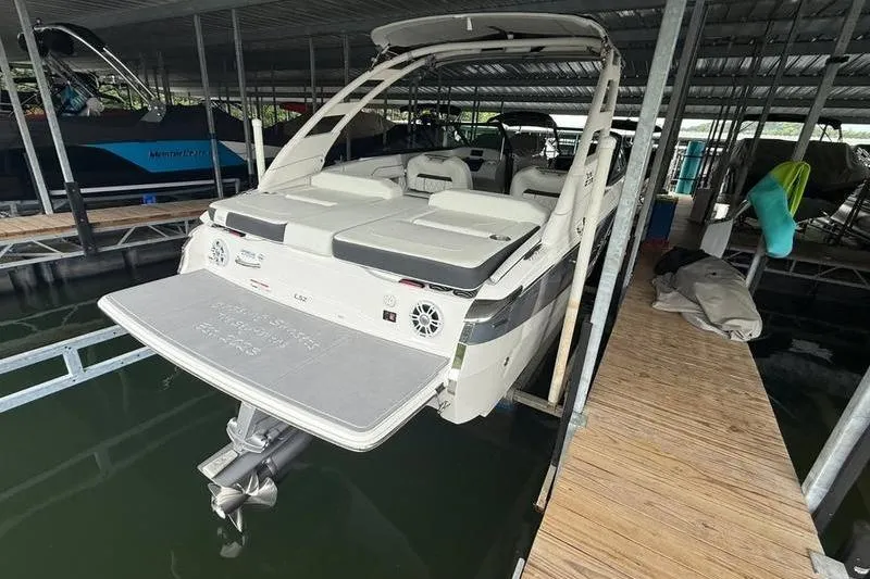 Slide: The Image of 2023 Regal LS2 boat docked in a covered marina, rear view. - 4